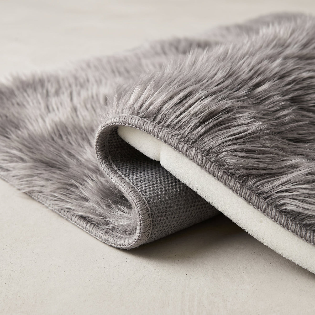 Détail du bord du Tapis de Bain Fausse Fourrure Moelleux Gris