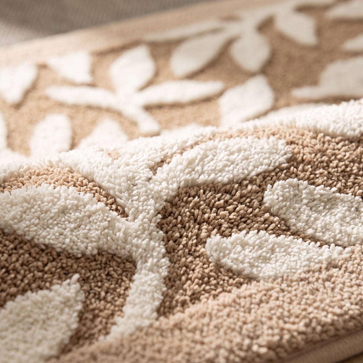 Gros plan sur la microfibre et le motif feuilles éparses, coloris beige