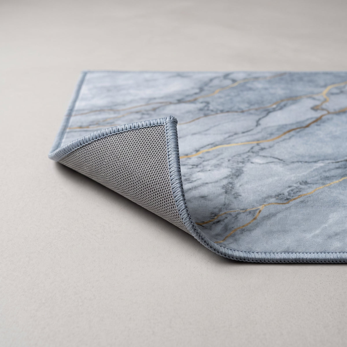 Détail du bord du Tapis de Bain Marbre Nordique Bleu Gris
