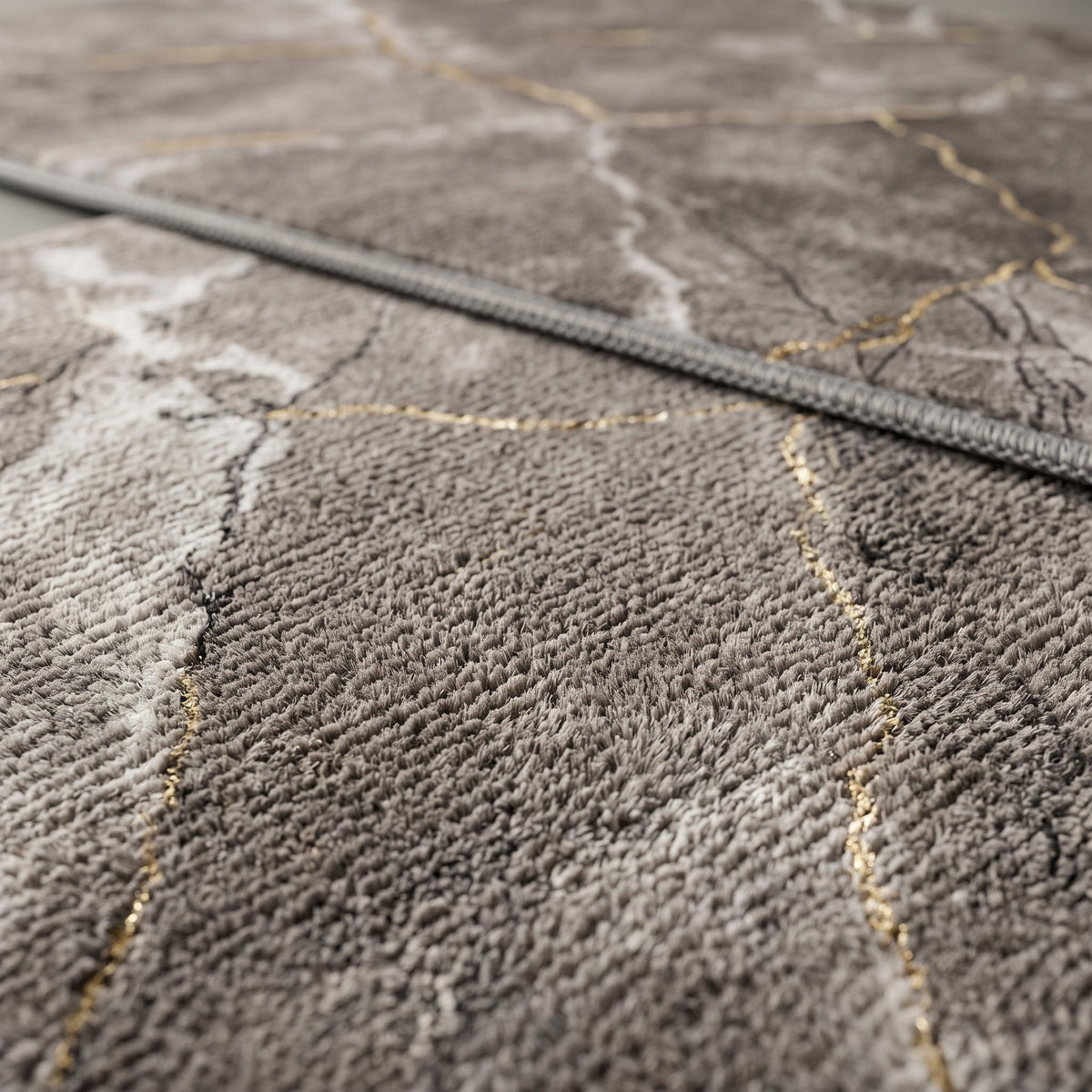 Gros plan sur le veinage du Tapis de Bain Marbre Nordique Gris Doré