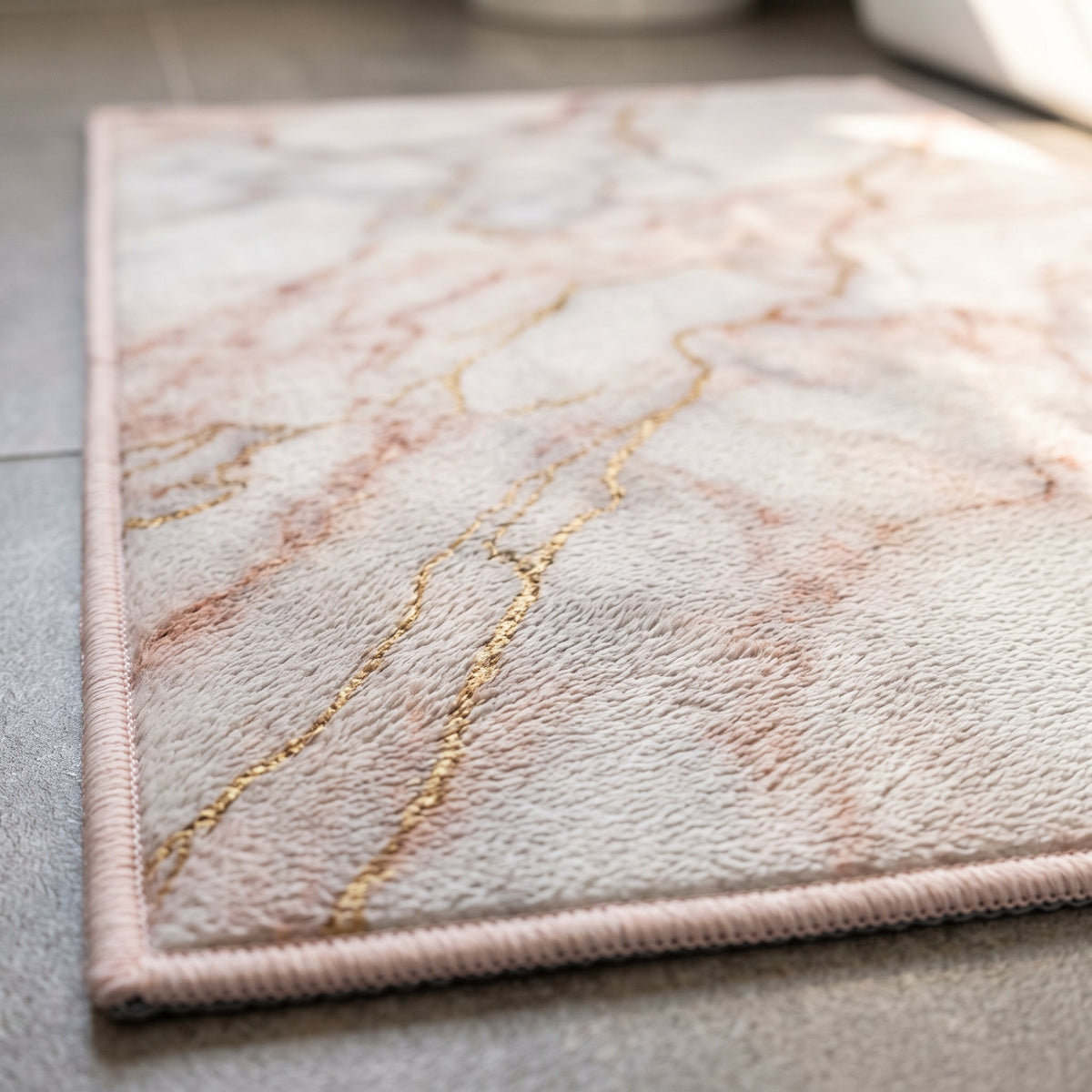 Gros plan sur le veinage du Tapis de Bain Marbre Nordique Rose Doré